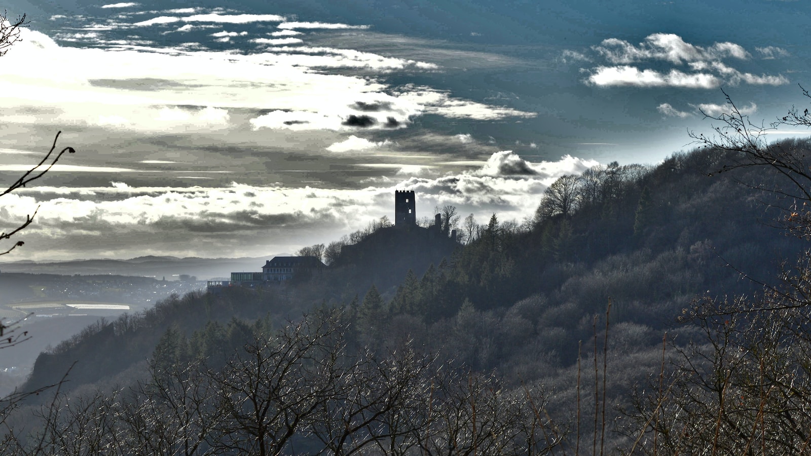 a view of a mountain with a clock tower in the distance